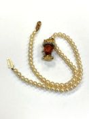 A 9ct gold mounted pearl necklace with yellow gold mounted head pendant