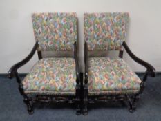 A pair of carved oak early 20th century scroll arm armchairs in a tapestry fabric