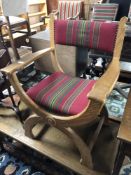 A 20th century blonde oak armchair on X frame legs,