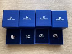 Four Swarovski crystal dress rings in retail boxes.