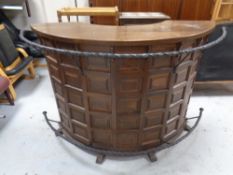 A demi-lune cocktail bar with wrought iron hand and foot rails