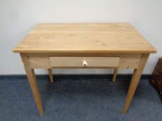 An early 20th century stripped pine side table fitted a drawer