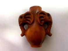 A Japanese carved fruitwood netsuke - Vase With Elephant Head Handles.