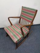 A mid 20th century teak rocking chair in a striped fabric