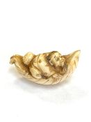 A Japanese carved netsuke depicting a Gentleman in boat, length 50 mm.