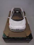 A Maisto 1:12 scale die cast Jaguar XJ220 1992 police car on plinth