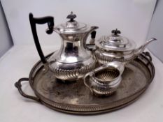A silver plated oval twin handled serving tray together with a Sheffield plated three piece tea