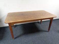 An Edwardian oak table on castors, length 168 cm x width 90 cm.