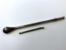 A silver swizzle stick and a hash pipe