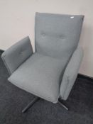 A contemporary swivel desk chair in grey buttoned fabric