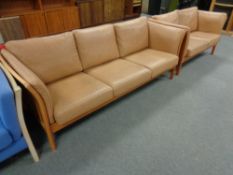 A Danish Skalma beech framed three seater settee and two seater settee in brown leather