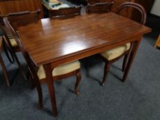 A mahogany table together with a pair of balloon backed chairs