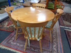 A circular pine table together with four chairs