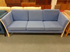 A Danish wooden framed three seater settee in blue fabric