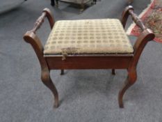 An Edwardian mahogany storage piano stool containing sheet music
