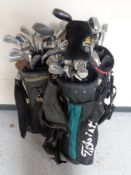 Three golf bags by Callaway Taylor Made titleist containing a large quantity of assorted golfing