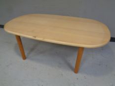 A oval coffee table in a pine finish