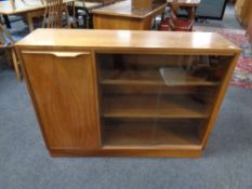 A set of mid 20th century teak sliding glass door book shelves fitted cupboard