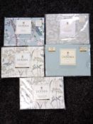 A basket of five packs of Dorma pillow cases (various patterns)