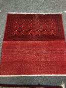 An eastern fringed cushion cover on red ground,