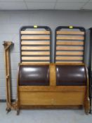 A contemporary 5' French walnut style bed frame with leather padded headboard