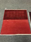 An eastern fringed cushion cover on red ground,