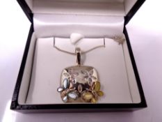 A silver pendant on chain.