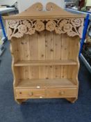 A pine wall mounted plate rack fitted with two drawers