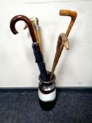 A West German vase containing four walking sticks and an umbrella