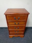 A yew wood narrow five drawer chest.