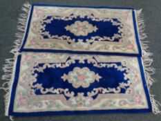 A pair of Chinese floral fringed rugs on blue ground