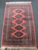 A Lahore Bokhara rug, Pakistan, on salmon ground,