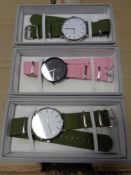 A box containing a quantity of Lyfe wristwatches on fabric straps.