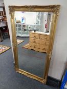 A Victorian style gilt framed bevel edged overmantel mirror in a swept frame