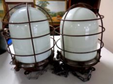 A pair of vintage bulkhead lights in metal cages with opaque glass shades