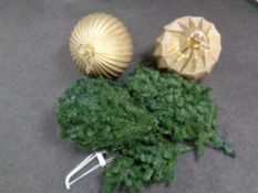A 7' pre lit Christmas tree together with two over sized Christmas baubles