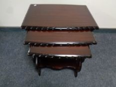 A nest of three tables in a mahogany finish