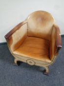 An X-frame armchair upholstered in studded leather