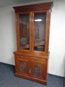 A Victorian mahogany double door book case fitted cupboards and drawers beneath