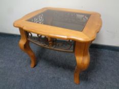 A pine and wrought iron lamp table on shaped legs with glass inset top