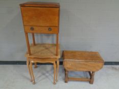 An oak work table together with a small drop leaf table and a nest of two tables