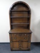 An oak dome topped dresser fitted cupboards and drawers beneath