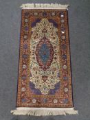 A silk-piled fringed Persian rug.