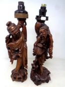 A pair of carved Chinese hardwood figural table lamps