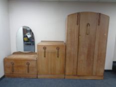 An early 20th century oak three piece bedroom suite comprising single door wardrobe,