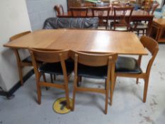 A mid 20th century teak extending dining table fitted a leaf together with a set of six teak chairs