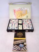 A Mahjong set in case together with accompanying book