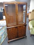 A 20th century walnut double door glazed bookcase fitted cupboards below