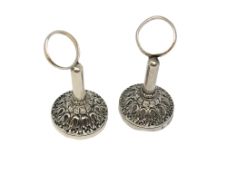 A pair of ornate silver napkin holders,