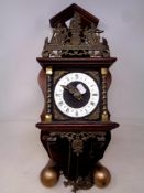 A decorative Dutch wall clock with brass pear drop weights